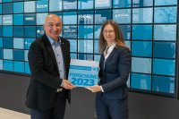 Fuat Eker, Director of Sales, Marketing and Customization bei der ColVisTec AG, erhält die Plakette als Premiumpartner Forschung von Dr. Linda Mittelberg, Gruppenleiterin Spektroskopie am SKZ