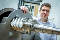 Bild 1: Prof. Simon Klink neben einem Verdichter für Industrieanwendungen