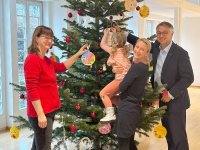 Abteilungsleiterin des Kinder- und Jugendbereichs der SOZIUS Pflege- und Betreuungsdienste Schwerin gGmbH Silke Schönrock, Demmlerhaus-Leiterin Carolin Schulz und WEMAG-Vorstand Thomas Murche (v. l.) bringen die Karten mit den Wünschen der Kinder am Weihnachtsbaum im WEMAG-Speisesaal an. Foto: WEMAG/Laura Maaß