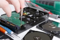 Techniker untersucht eine defekte Festplatte – symbolisch für professionelle Datenrettung und forensische Analyse.