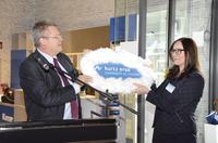Kurtz Ersa-Chef Rainer Kurtz übergibt den virtuellen Schlüssel zur Hammer Academy in Form einer Wolke bzw. Cloud an Kanzlerin Verena Alina Bartschat.