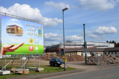 Oben Nagelplattenbinder, unten Lebensmittelmarkt: In Baumholder eröffnete 2018 ein Edeka-Markt mit einem Dachtragwerk aus Nagelplattenbindern. Die freitragende Konstruktion besteht aus 50 jeweils 34,20 m langen Satteldachbindern sowie 25 jeweils 12 m langen Pultdachbindern. Foto: Achim Zielke für Meilinger Holzbau/GIN, Ostfildern; www.nagelplatten.de