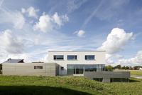 Südansicht des Einfamilienhauses in Brettheim: Durch den Bodenversatz zwischen den Nutzungsbereichen Wohnen und Essen im Erdgeschoss konnte das im Kellergeschoss angesiedelte Büro für einen optimierten Tageslichteinfall noch weiter aus dem Gelände gehoben werden / Bildnachweis: Schüco International KG