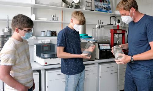 IMFAA-Mitarbeiter Benjamin Uhl zeigte im Pulverlabor wie Metalle gemahlen werden können und experimentierte mit den Schülern Johannes Memmert (links) und Benjamin Vollprecht (rechts) zum Thema additive Fertigung aus Metallen