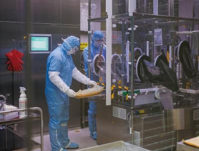 Der Blick in die Impfstoffabfüllung ist bei laufender Produktion nur hinter der Glasscheibe möglich. Die Mitarbeiter Björn Dalichau und Andreas Müller bereiten die Linie für die Abfüllung des SARS-CoV-2-Impfstoffkandidaten vor