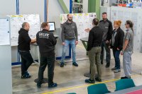 Tägliche Stehung in der Motorfertigung: Jeden Morgen treffen sich SELVE-Produktionsmitarbeiter und Führungskräfte zur Besprechung. Gemeinsam werden wichtige Kennzahlen abgeglichen und etwaige Abweichungen bewertet. So entsteht ein klares Bild über den aktuellen Produktionsstatus
