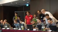 XIMEA CEO Max Larin (center, green shirt) talks with other attendees of the AIA/EMVA USB 3 Vision standard development plugfest held in Dresden, Germany