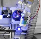 Ein Vakuumgreifer aus abriebfestem Kunststoff entnimmt die Werkstücke aus dem Blister, richtet sie aus und bringt sie mit der zu beschriftenden Fläche in den Laserstrahl