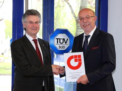(v.l.n.r.): Richard Lang, BVMW-Verbandsbeauftragter für die Wirtschaftsregion Augsburg, übergibt das Partnerzeichen an Wolfgang Heinritz, Leiter der Augsburger Niederlassung der TÜV SÜD Industrie Service GmbH