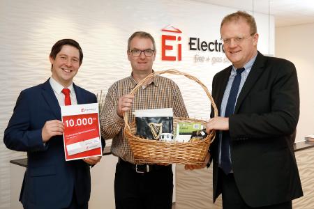 Geschäftsführer Philip Kennedy (r.) und Referent Robert Schmidt (l.) von Ei Electronics überreichten der zehntausendsten Fachkraft für Rauchwarnmelder Michael Rempe einen Präsentkorb mit irischen Spezialitäten