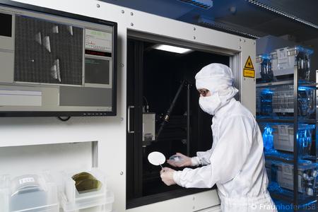 Operator loading a 100 mm SiC epiwafer in the defect luminescence scanner at Fraunhofer IISB