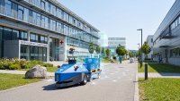 INDUROS 700 mit angekoppeltem Transportwagen im Außeneinsatz auf einem Klinik-Campus