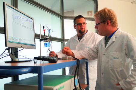 Dr. Robert Gerke (links) und Dr. Mathias Schnippering besprechen die Ergebnisse einer Elektrolyt-Untersuchung, durchgeführt mit einem Potentiostaten.