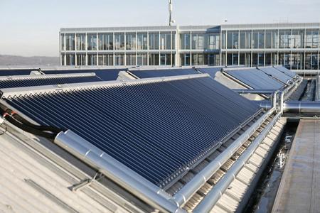 Teil des Kollektorfeldes und des Nachbargebäudes, das mit Solarwärme und -kälte versorgt wird.