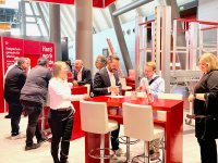 HYMER-Steigtechnik auf der A+A 2025 in Düsseldorf: Halle 4, Stand 4G06 – praxisgerechte Lösungen für sicheres Arbeiten in der Höhe. Die gezeigte Arbeitsbühne lässt sich elektrisch in der Höhe verstellen. Auch die Treppe kann automatisch angepasst werden.