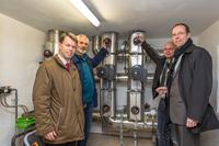 WEMAG-Vorstand Caspar Baumgart, Bürgermeister Klaus Weinreich, Michael Schütt, Leiter Energiedienste, und Dr. Christian Frenzel, Abteilungsleiter im Energieministerium (v.l.) nehmen das Nahwärmenetz in Bresegard in Betrieb. Foto: WEMAG/Rudolph-Kramer