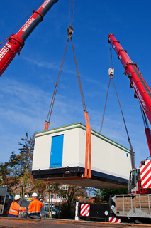 Zwei Spezialkräne heben die über 50 Tonnen schwere Schaltstation der WEMAG vom Tieflader und setzen sie auf das vorbereitete Fundament. Foto: WEMAG/Rudolph-Kramer