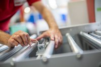 Ein Mitarbeiter der romwell GmbH & Co. KG bei der Montage an einer Twistpac-Verpackungsmaschine – moderne Fertigungstechnologie trifft auf präzise Handarbeit im Rahmen der digitalisierten Produktionsprozesse.