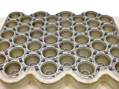 Thermoformwerkzeug zur Produktion von Polypropylen-Bechern. Die olivfarbene HART-COAT®-Schicht ist auf den Formen gut zu erkennen