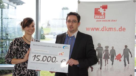 Nadine Otta, verantwortlich für das Fundraising der DKMS, nimmt den Spendenscheck über 15.000 Euro von Mirko Herrmann, Leiter Marketing & Communications der SER-Gruppe, in Empfang.