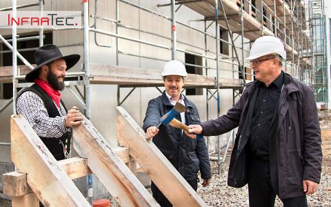 The Managing Directors Dr. Matthias Krauß (right) and Dr. Matthias Heinze (middle) symbolically strike the last nail at the topping-out ceremony