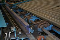 Maschine mit Kugelrollen bei der Magotteaux Liège Mettac, mit deren Hilfe Metallstangen transportiert werden