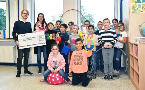Die Kinder der Heiligenwegschule mit ihrer Schulleiterin Julia Germelmann freuen sich über die Spende von secova. Überreicht wurde sie durch secova-Mitarbeiter Jan Hasse - der Osnabrücker hatte die Schule als Spendenempfänger vorgeschlagen.