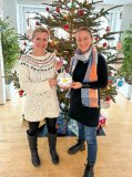 WEMAG-Mitarbeiterin Jenny Apitz und die Leiterin des Demmlerhauses Carolin Schulz (v. l.) hängen die Karten mit den Wünschen der Kinder an den Weihnachtsbaum im WEMAG-Speisesaal.