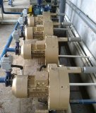 Dieses Bild zeigt eine Installation mehrerer Seitenkanalverdichter in einer industriellen Umgebung. Die Geräte sind in einer Reihe angeordnet, mit klar erkennbaren Rohren und Anschlüssen für Zu- und Abströmung. Die goldene Farbgebung der Verdichter hebt sie optisch hervor. Dieses Setup verdeutlicht die Skalierbarkeit und die Möglichkeit, mehrere Verdichter modular in ein System zu integrieren, um spezifische Anforderungen, wie erhöhte Druck- oder Volumenstromkapazitäten, zu erfüllen.