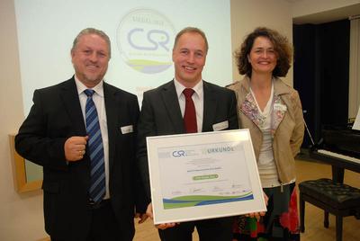 SIVIS-Geschäftsführer Kai Bounin (Mitte) präsentiert die Auszeichnung.
Juryvorsitzender Dr. Hans-Christof Berger (l.) und Moderatorin Birgit
Probost freuen sich mit ihm, Foto: JaMedia