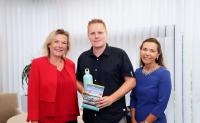 Tim Bäßler least das hundertste JobRad bei CONET – Geschäftsführerin Anke Höfer (links) und Personalleiterin Sabine Cox überreichten ihm das Buch 
