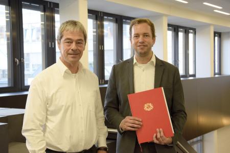 Es zeigt Prof. Dr. Stefan Veltel mit dem ehemaligen Konrektor für Studium und Lehre, Prof. Dr. Axel Viereck, bei der Übergabe der Ernennungsurkunde / Foto: Hochschule Bremen / Sascha Peschke