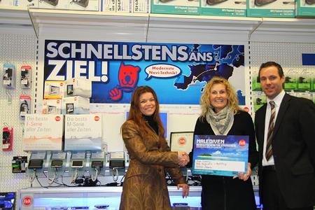Heike Huber (Mitte) vom Euronics-Fachmarkt, Döbeln, nimmt den Gewinn freudestrahlend entgegen. Überreicht wurde er ihr von Susanne Hirth, Falk Trade Marketing Managerin (re.) und Jan Streubel, Falk Regional Sales Manager (li.).