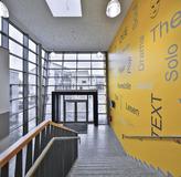 Integrierte Gesamtschule Kaufungen: Die markante, gelbe Wand erscheint wie ein Gesamtkunstwerk. Bei Dunkelheit strahlt die Farbe schon von außen einladend durch die Glasfront.