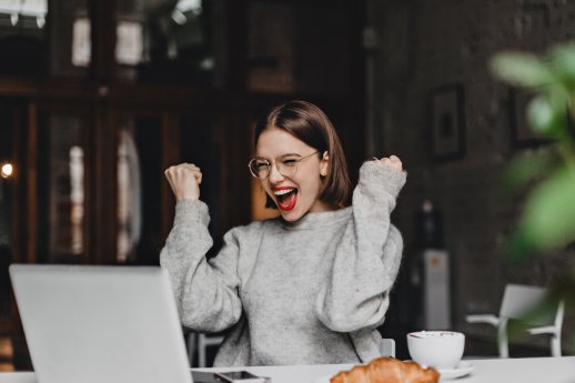 happy-woman-glasses-makes-winning-gesture-sincerely-rejoices-lady-with-red-lipstick-dressed-gray.jpg