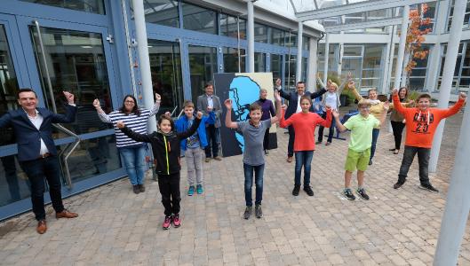 Die Freude ist groß in Edenkoben: Die Schüler mit ihren Lehrerinnen, dem Schulleiter (7.v.l.), dem Wettbewerbsleiter (1.v.l.), Vertretern des Schulträgers (5.v.l.) sowie die Vertreterin der Schulaufsicht (2.v.r.). In der Mitte die Vertreterin der Chemieverbände (8.v.r.), die den Schulpreis förderten.