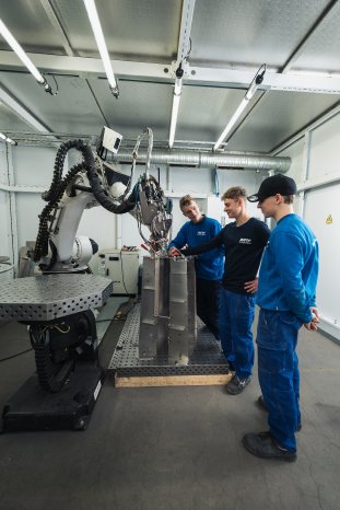 Tobias Melches erklärt den Auszubildenden den Laserschweiß-Roboter_4.jpg