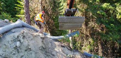 Foto der Installation der neuen Abfangwände durch den Bagger des Typs Hitachi 180