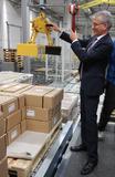 Beim Rundgang legte der hessische Wirtschaftsminister auch selbst Hand an und brachte an einer Hebevorrichtung ein Paket auf den Weg zu Rittal Kunden. Quelle Rittal GmbH & Co. KG 
