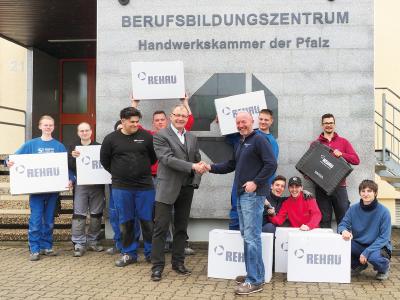 Gemeinsam mit Auszubildenden der Handwerkskammer der Pfalz freuen sich Erik Schehl (6.v.r.), Leiter der außerbetrieblichen Ausbildung bei der Handwerkskammer der Pfalz, und Norbert Reisinger (6 v.l.), Außendienstmitarbeiter beim Polymerexperten REHAU im Verkaufsbüro Frankfurt, über die REHAU Spende von zwölf Werkzeugeinheiten RAUTOOL für die Installation von Trinkwasser- und Heizungsrohrsystemen, Foto: Handwerkskammer der Pfalz
