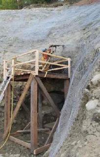 Foto der Installation der neuen Abfangwände durch den Bagger des Typs Hitachi 180