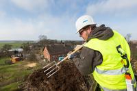 Ulf Bähker vom NABU-Landesverband Mecklenburg-Vorpommern reinigt sorgfältig ein Storchennest in Benzin, Foto: WEMAG/Rudolph-Kramer