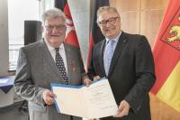 Regionspräsident Hauke Jagau überreicht die Auszeichung an Bodo Messerschmidt. Foto: Region Hannover / Claus Kirsch