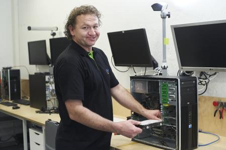 Ein AfB-Mitarbeiter repariert einen PC