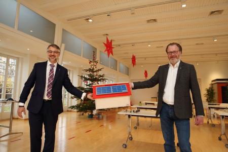 WEMAG-Vorstand Thomas Murche (li.) überreicht dem Geschäftsführer der Diakoniewerk Neues Ufer gGmbH Thomas Tweer symbolisch für die Kindertagesstätten im Netzgebiet das Geschenk der diesjährigen Kita-Weihnachtsaktion