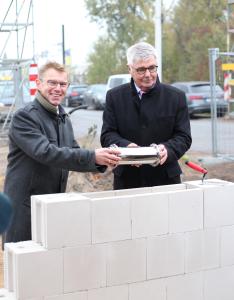 Der Vorsitzende und Aucotec-Mitgründer Horst Beran und sein Vorstandskollege Uwe Vogt legen den Grundstein für die neue Firmen-Zentrale. (© AUCOTEC AG)