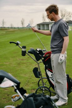 @FIDLOCK - Golf-Trolley mit VACUUM und TWIST - Mann zieht Schläger kompr..jpg