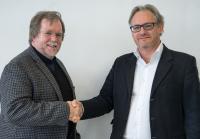 Stéphane Bussa, Vice President of Sales & Marketing, beglückwünscht Scott Jordan zur Ernennung als Leiter des Marksegments Photonik