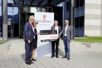 Prof. Friedhelm Loh, Inhaber und Vorstandsvorsitzender der Friedhelm Loh Group, und seine Ehefrau Debora Loh übergeben einen symbolischen Scheck über 25.000 Euro an den Verein 