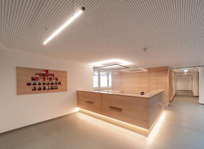 The staggered rectangular luminaire structures reflect the clear geometric shape of the reception desk in Canadian maple / © ArchitekturImBild - Bernhard Tränkle